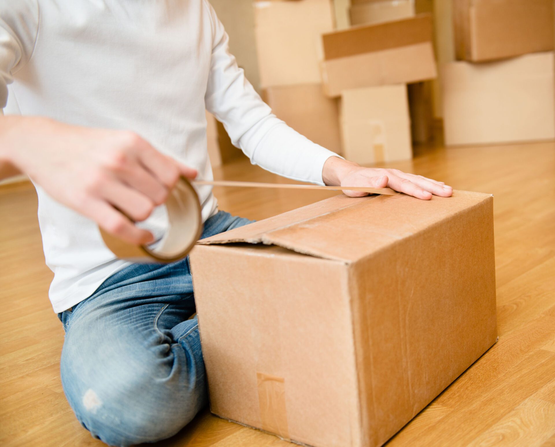 Close up of male hand packing cardboard box Close up of male hand packing cardboard box